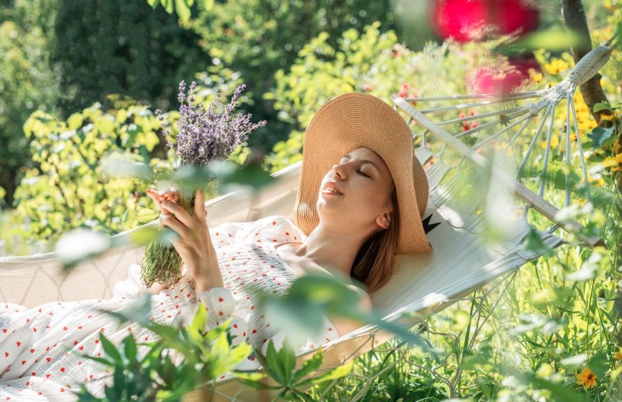 Frau liegt in Hängematte im Garten